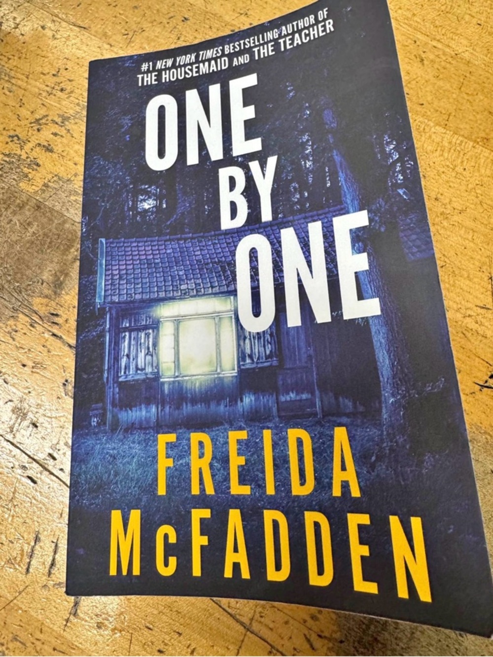 One By One by Freida McFadden - Dark Blue & Yellow Paperback